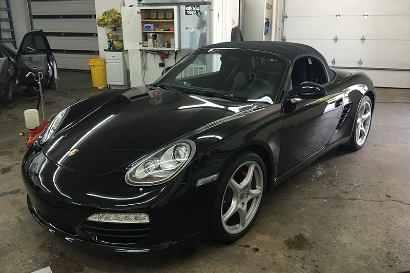 Professional applying Paint Protection Film to vehicle hood